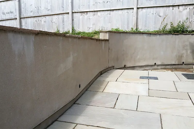 Rendered wall and patio after cleaning — clean render and fresh paving